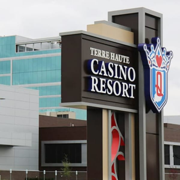 Terre Haute Casino Resort sign with a crown logo, against a building with blue windows.