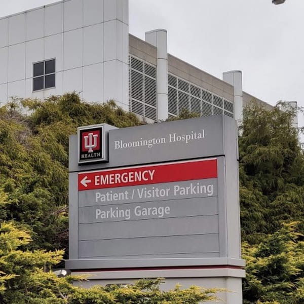 A hospital sign for Bloomington Hospital, Emergency, Patient/Visitor Parking, and Parking Garage.