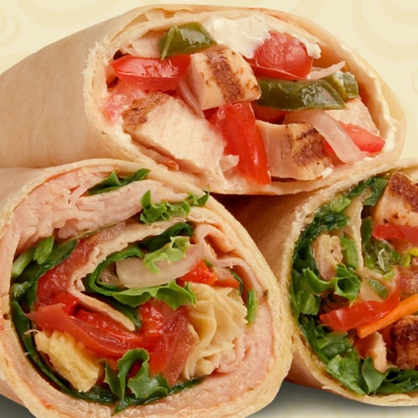 Three Roly Poly wraps, one with chicken, peppers, and cream cheese, another with turkey and lettuce.